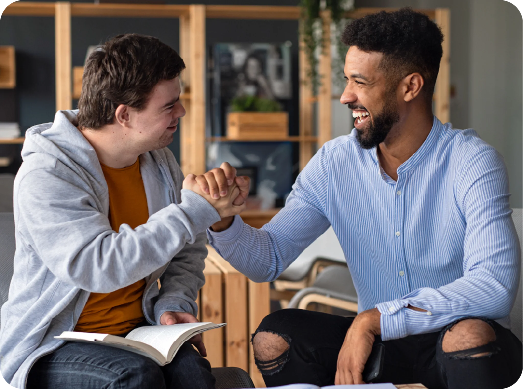Two men clasping hands and smiling during a one-to-one support session