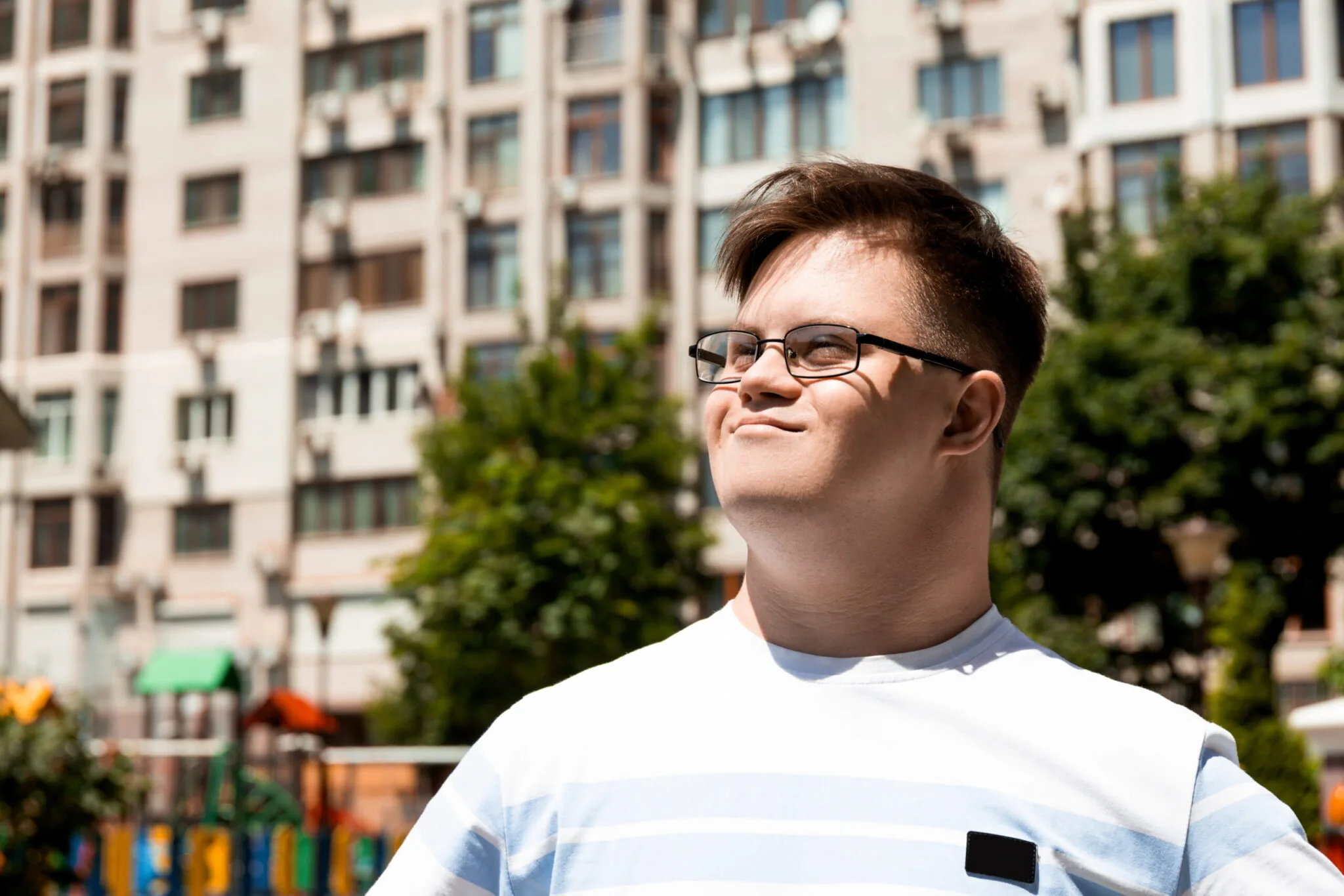 Smiling young man with Down syndrome wearing glasses